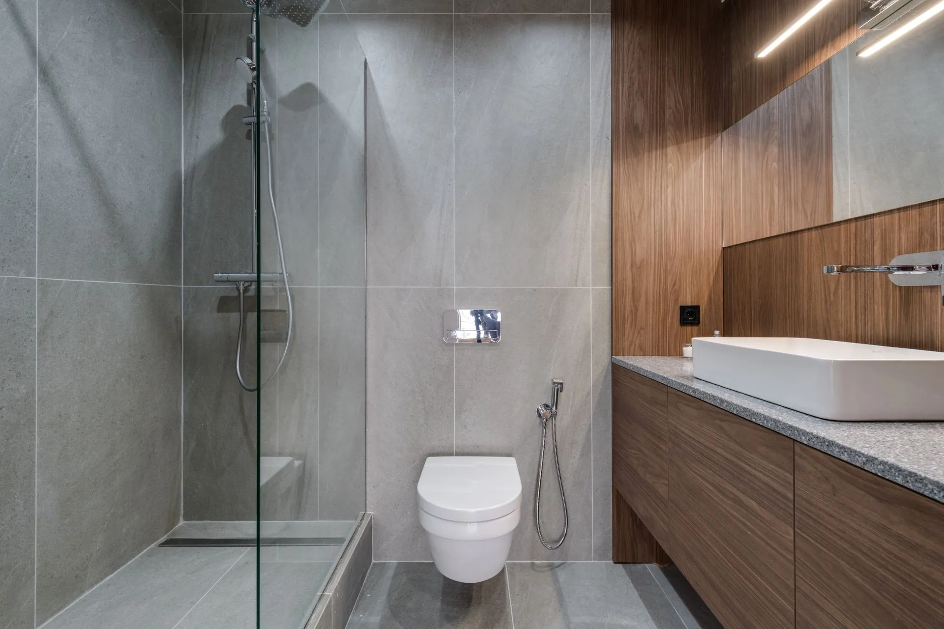 Bathroom with walk-in glass shower and wood vanity