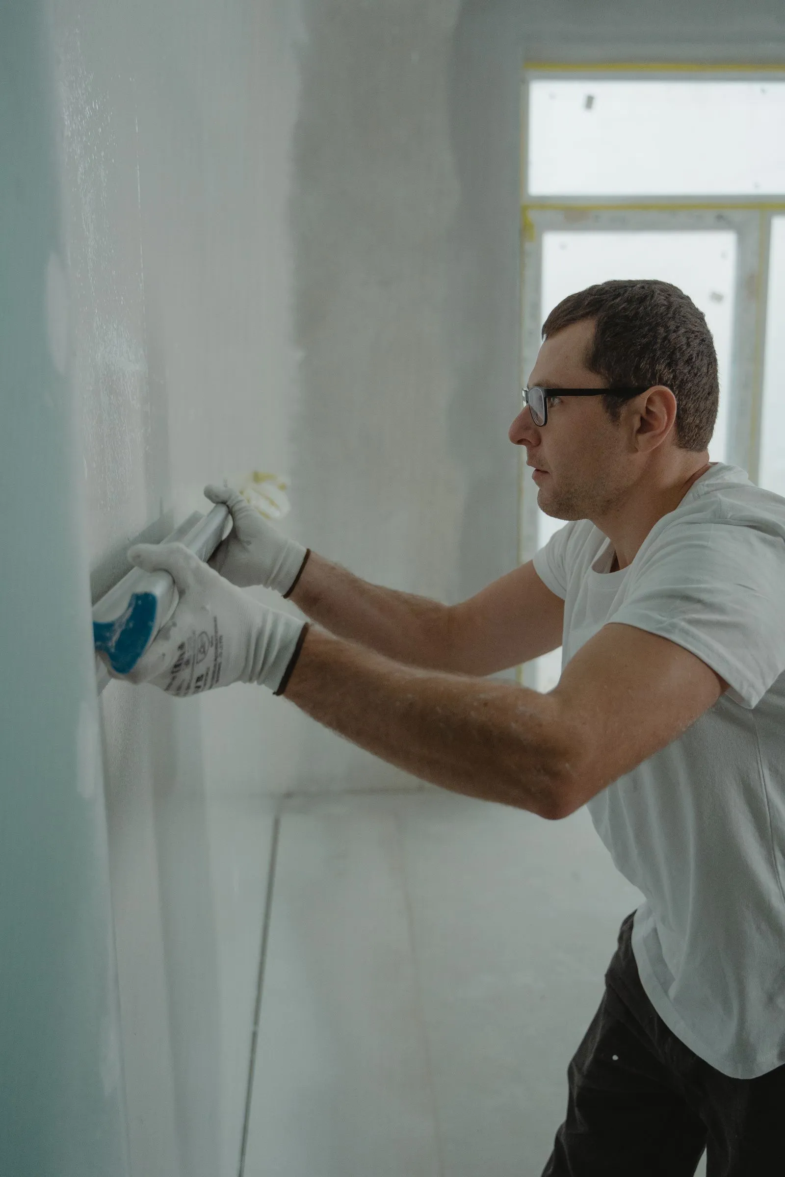 Tradesperson applying drywall compound