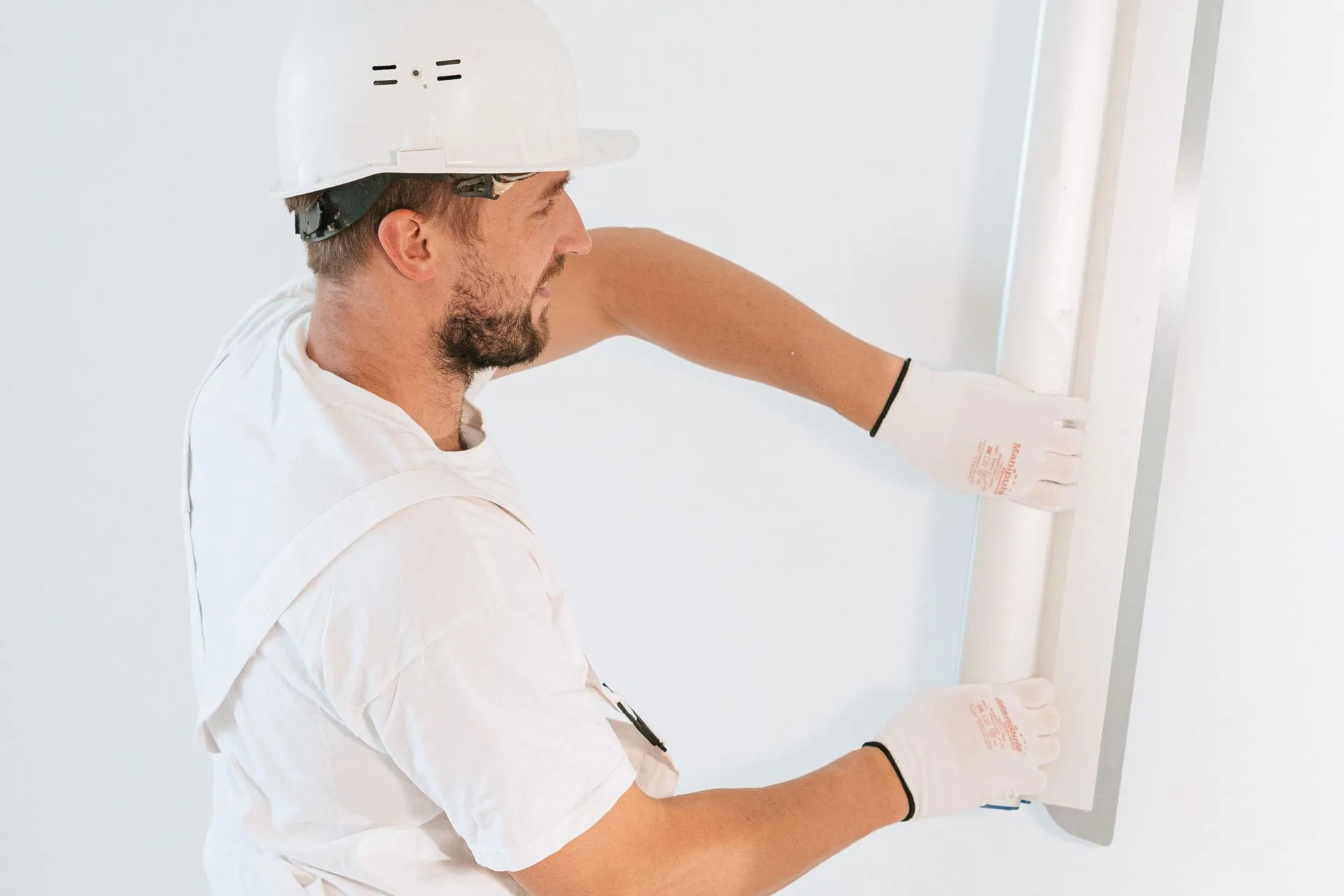 Tradesperson in a hard hat installing a wall panel